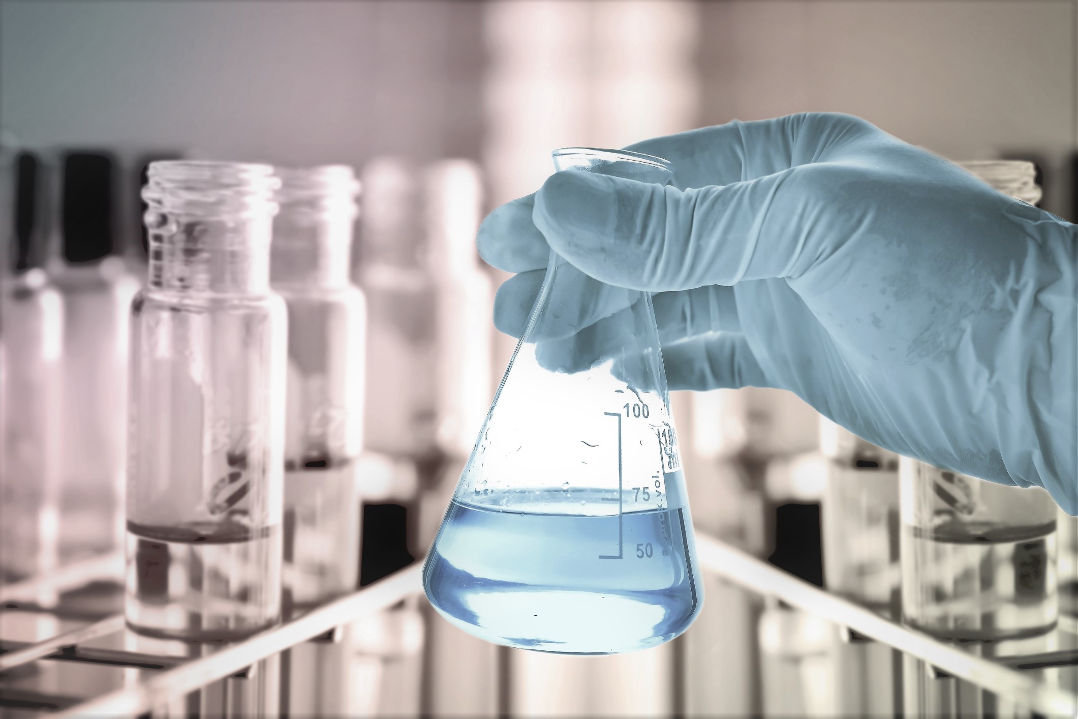 Flask in scientist hand and test tubes in rack Flask in scientist hand and test tubes in rack